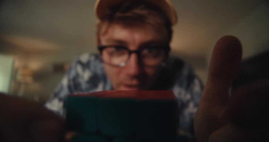 Closeup shot of a man spinning a rubiks cube with one hand after solving it