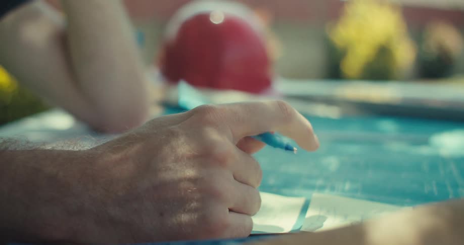 Man sitting outdoors with blueprints fidgeting with a pen