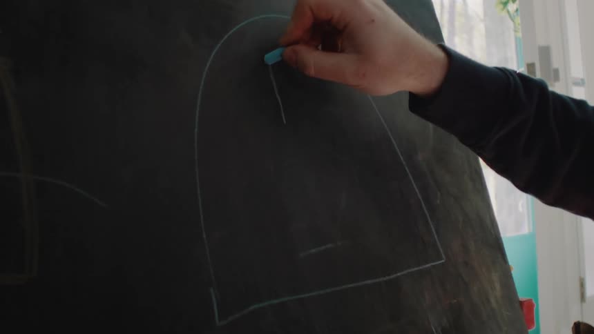 A person is sketching something on the chalkboard