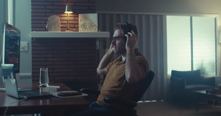 Man sitting in his living room gestures upset with the data displayed on his computer