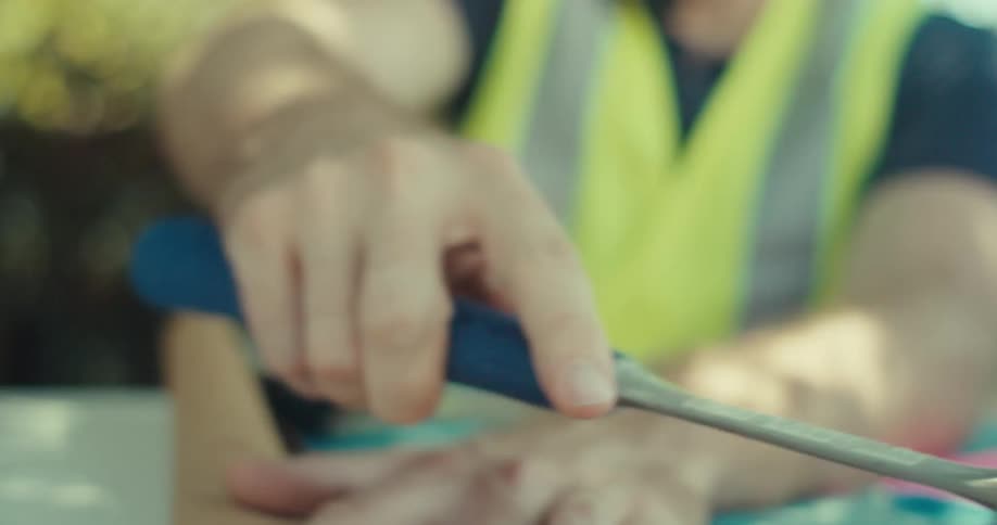 A man puts the hammer on the blueprints