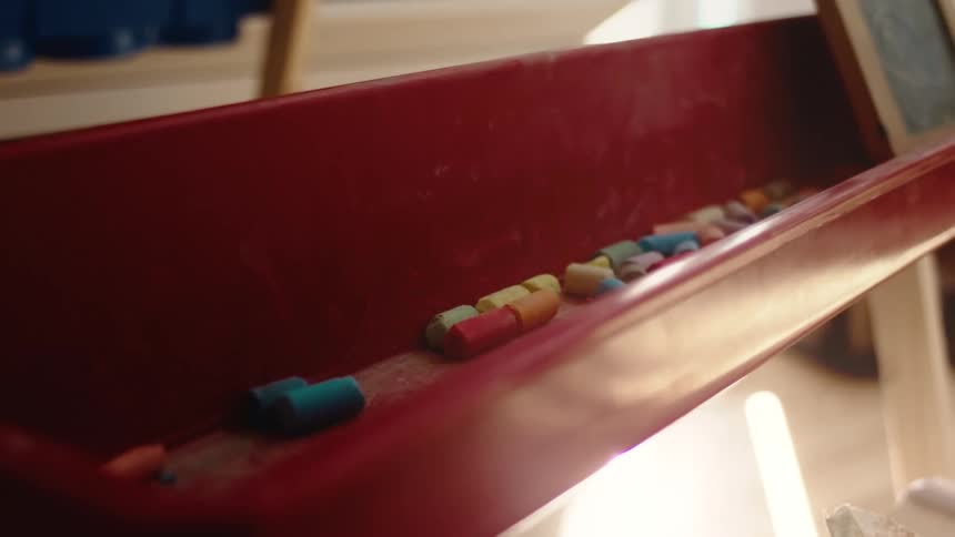Close up of various coloured chalks sitting in a chalk holder