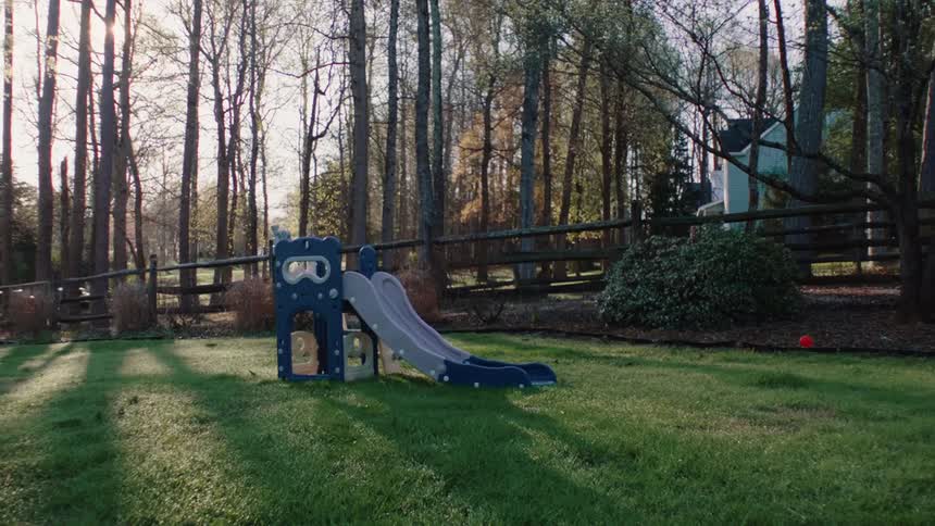 An outdoor slide toy on the grass near trees