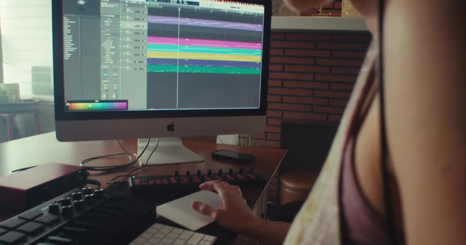 A woman types on the keyboard by the soundboard