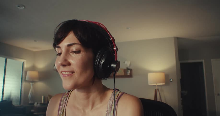 A woman puts on headphones and listens to music