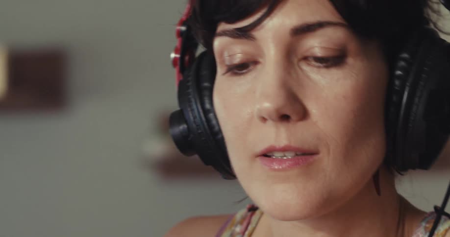 The woman turns the dial on the soundboard while listening to music