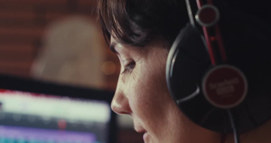 A woman in a room listening to music with headphones