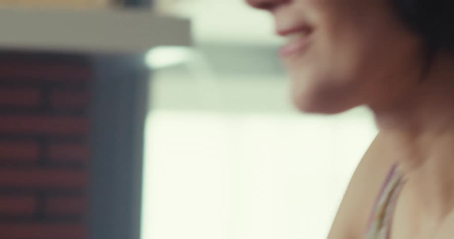 A woman wearing a headset vibes to a song in a music studio