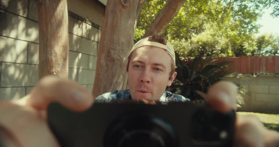 A man aims the camera on his cell phone