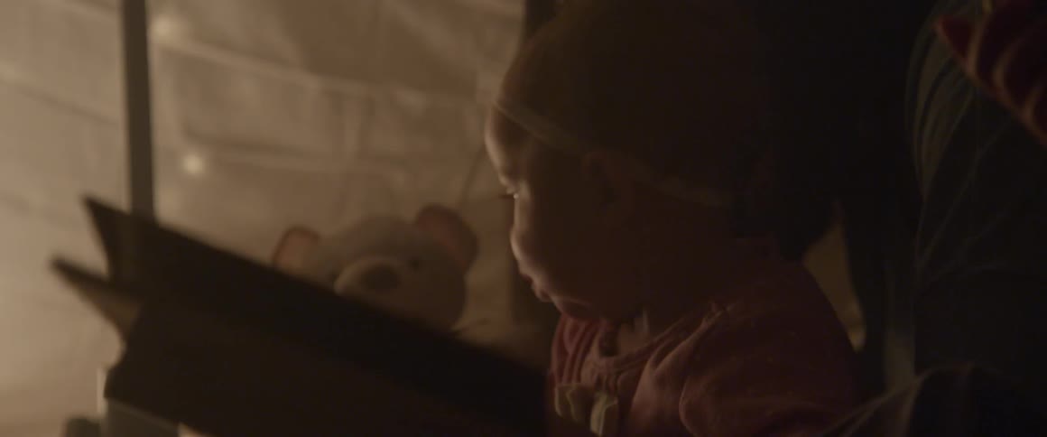 Woman making baby laugh with teddy bear