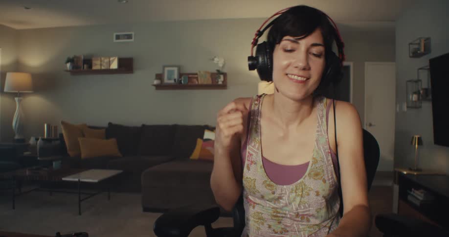 Woman happily dancing with headphones on enjoying music in a cozy living room