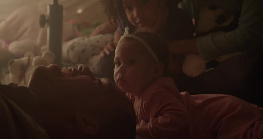 Children watch as dad plays with another child