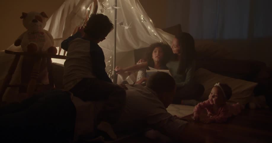 Parents and children spending time together at home at night
