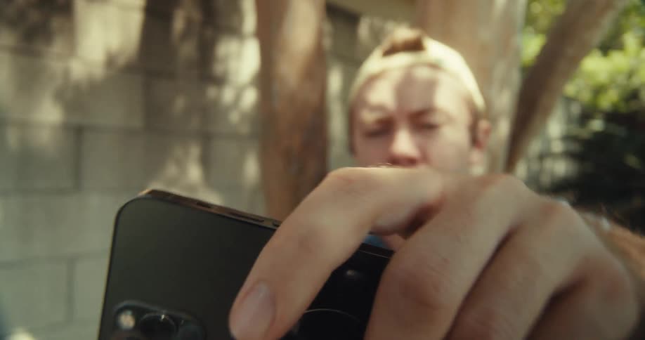 Close up of a man as he picks up an iphone towards his ear to take a call