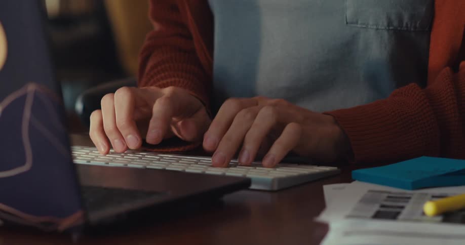 The woman is sitting at her desk typing