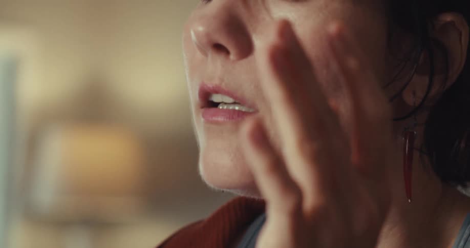 A woman looks worried and takes her glasses off
