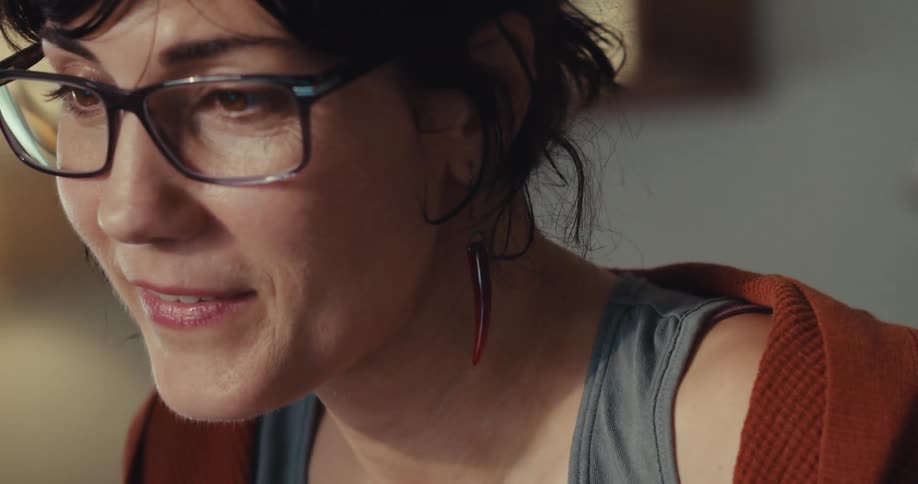 A woman smiles while writing on a post it