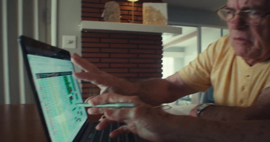 A man and woman talk while pointing at a spreadsheet on the laptop