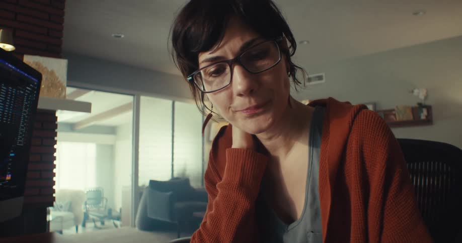 A woman is writing at her desk