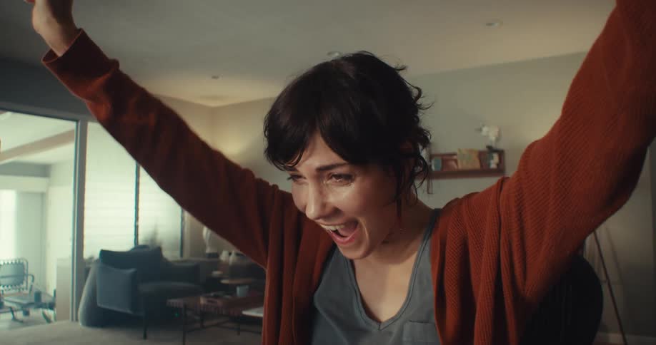 Woman celebrates after getting good news via her computer at home