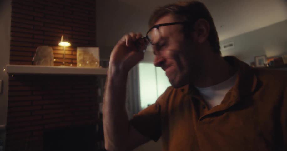 Man angrily stares at computer screen indoors after seeing stock market losses
