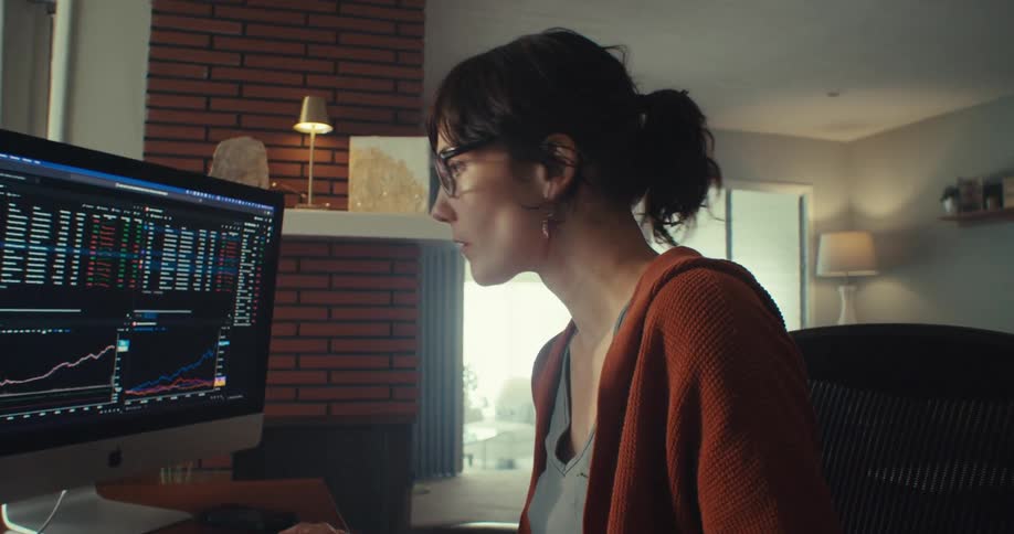 A woman uses the trackpad on her computer while reading information