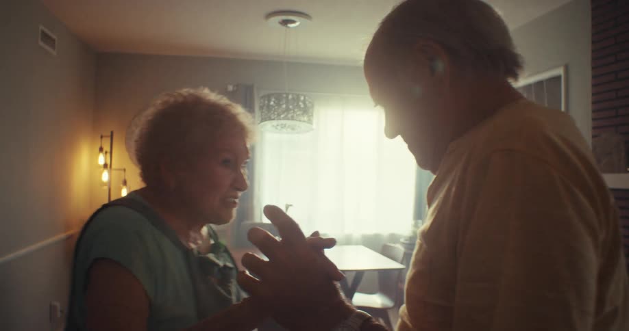 A man and woman dance together in a home