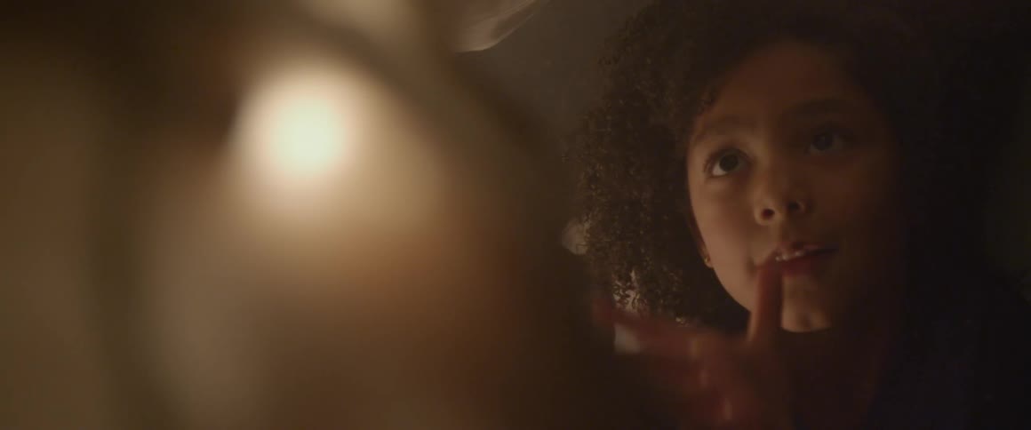 A young girl reaches and looks upward