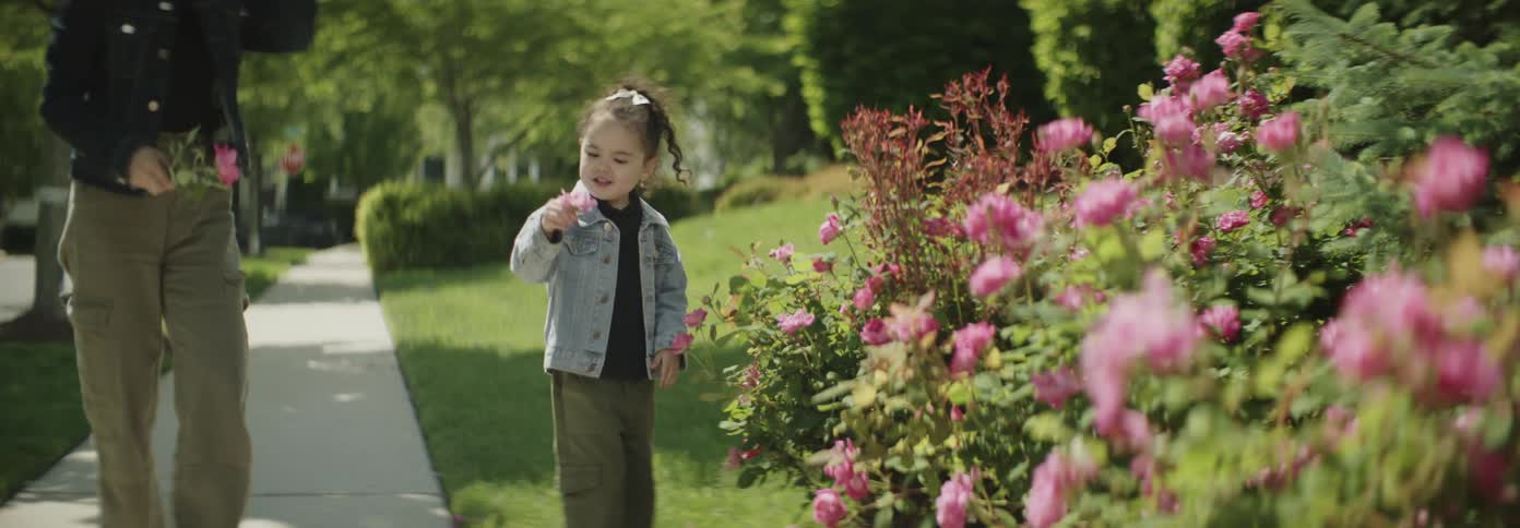 The daughter hands her mother a freshly picked flower