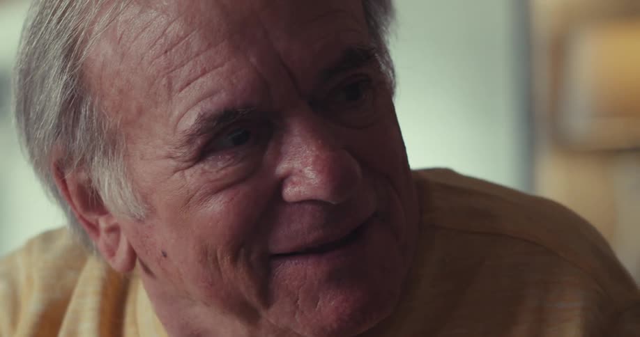 An elderly man and woman are having a talk as they smile