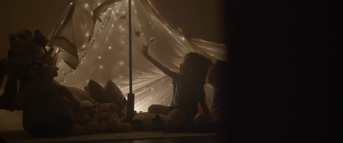 Young child reaching up to touch a hanging piece of origami