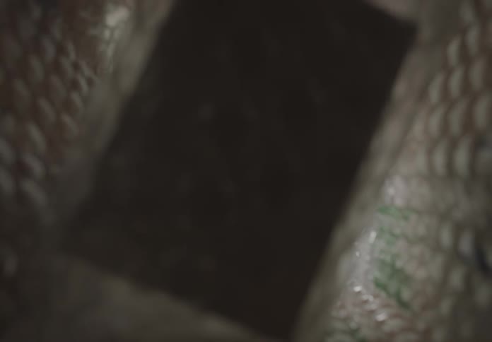 A man wraps a box in bubble wrap puts it in a container then removes and unwraps it