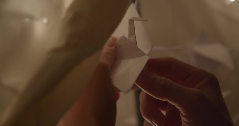 A person holds an origami bird