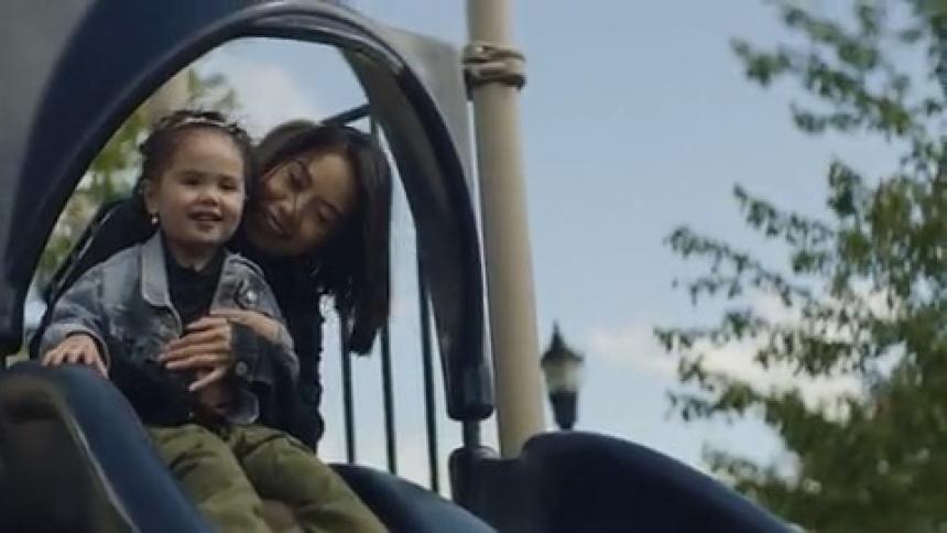 A mom and child go down the slide together