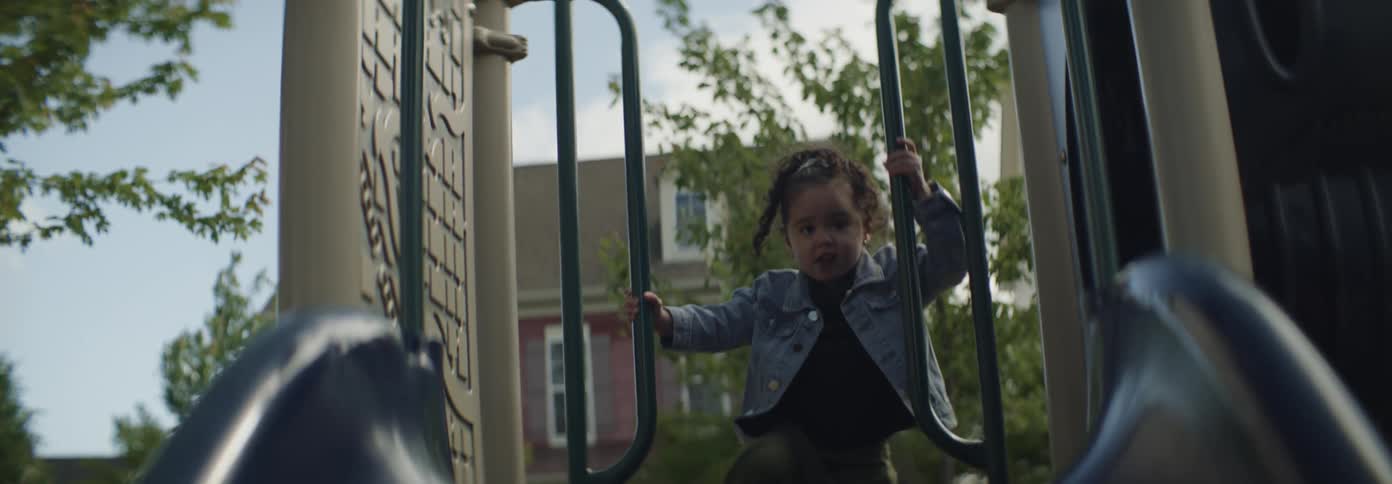 The little girl climbs the steps of the slide in the playground