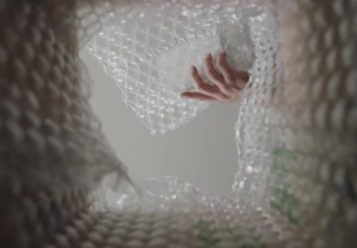 A man picks and unwraps a white package from a box