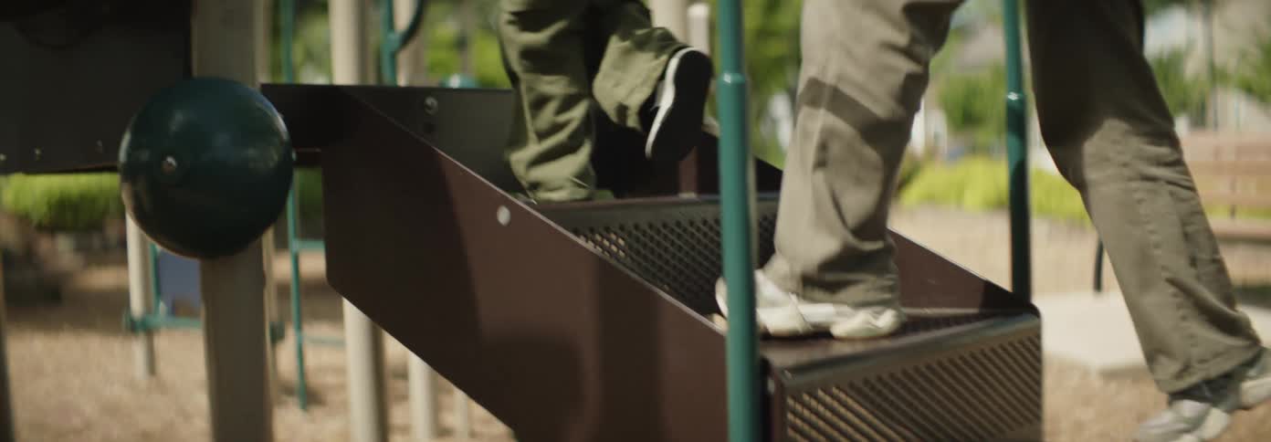 A mother and daughter climb the steps on the slide