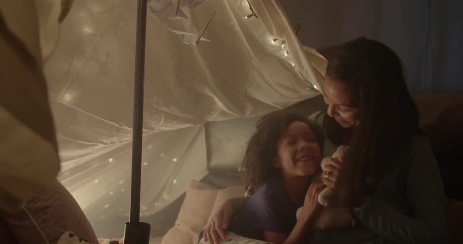 A woman and child hug holding a stuffed animal