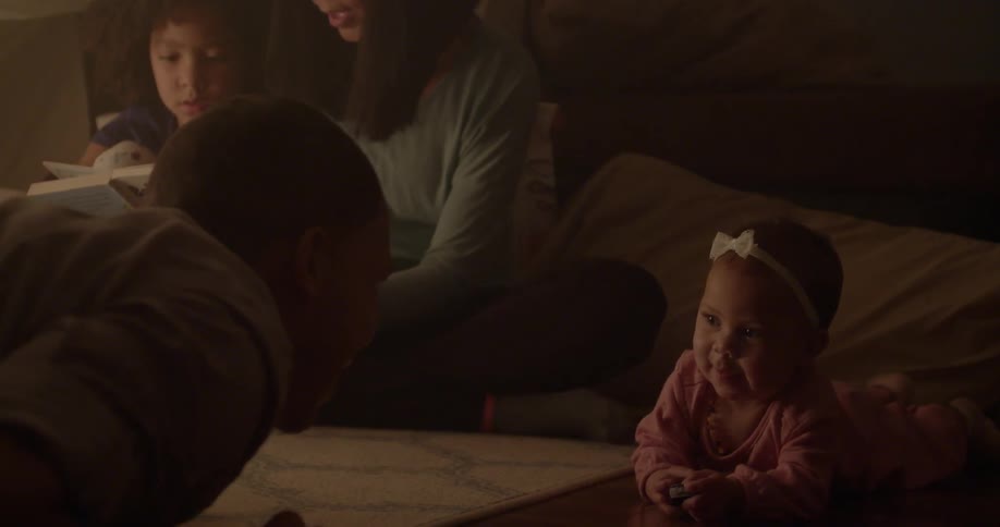 A family sits together and plays on the floor