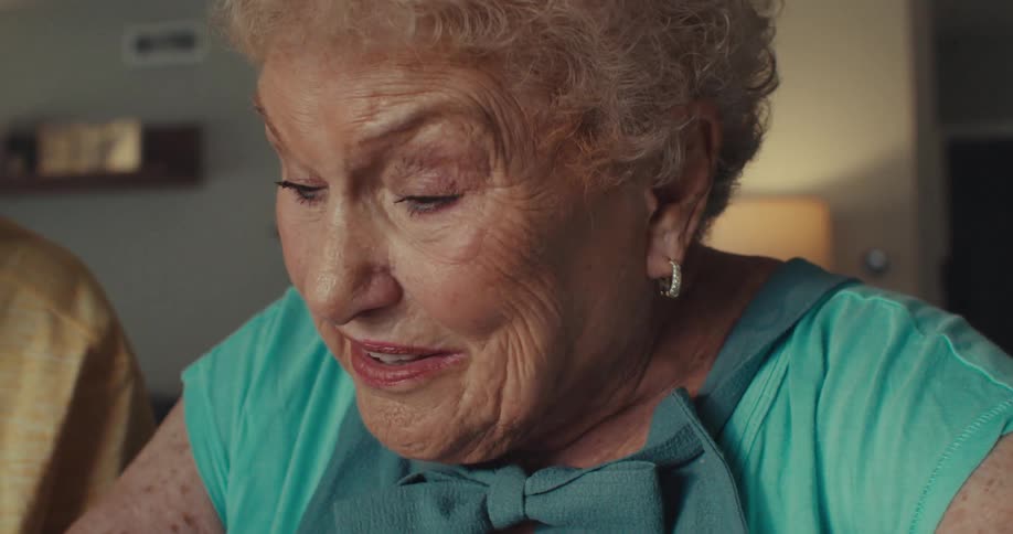 An elderly couple is discussing things animatedly the wife seems frustrated and she circles something on a form with a highlighter