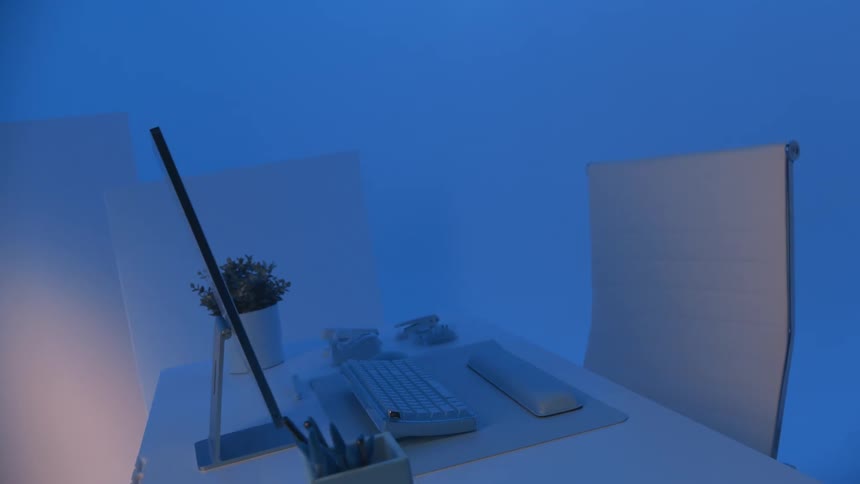 A sleek desk setup is revealed as the camera slowly twists around the monitor and chair