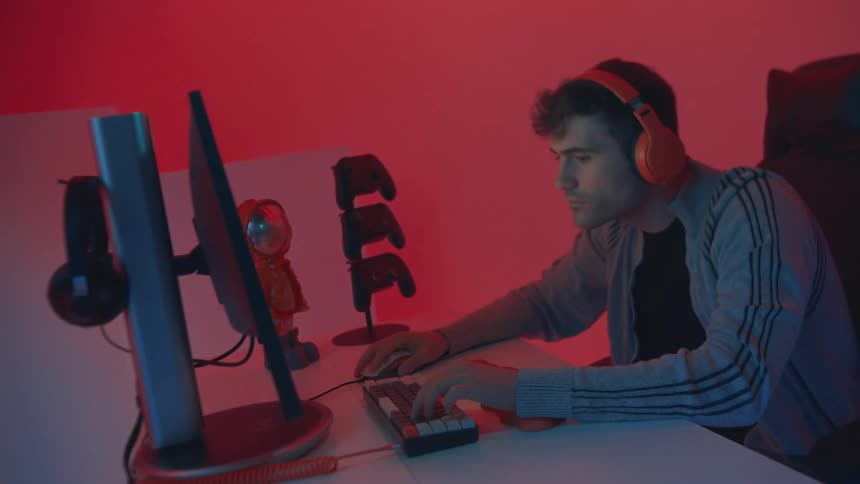 A man sitting at a table playing video games on a computer