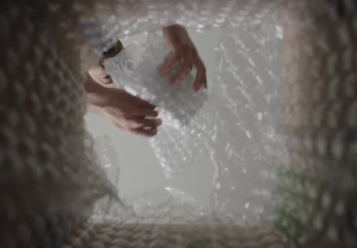A person pulls a smaller box out of a larger box