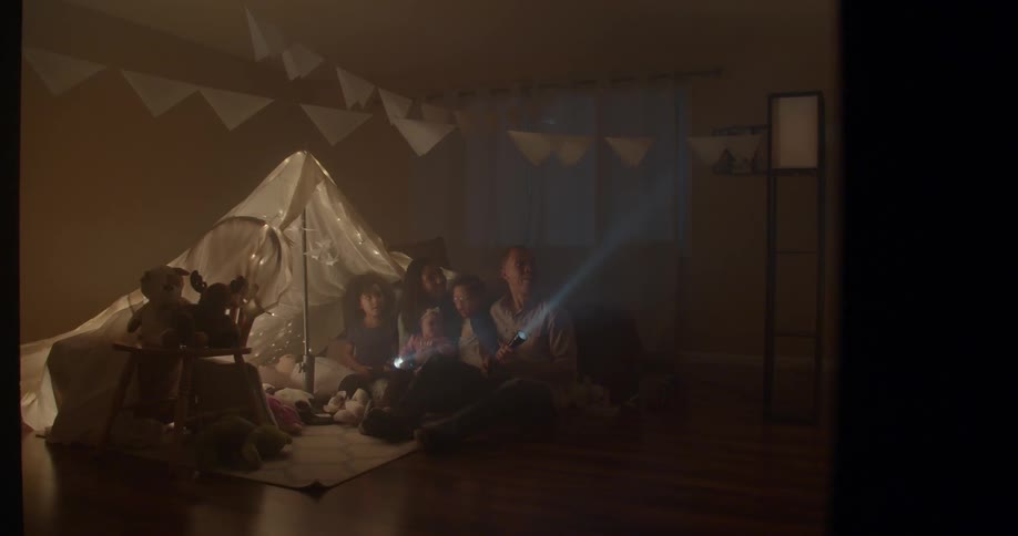 People near a tent are flashing a flashlight around