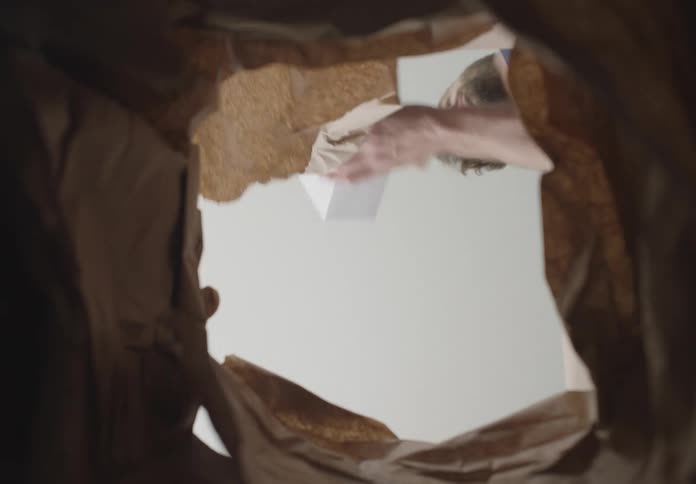 A man opens and unpacks a box viewed from inside the box