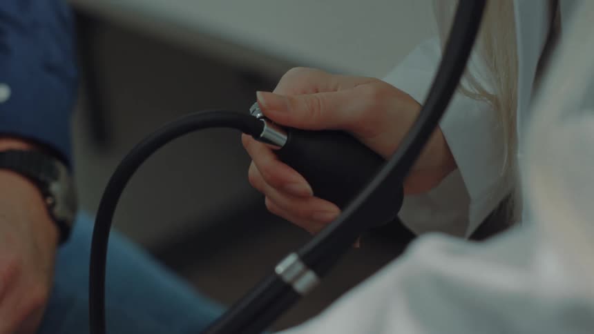 A doctor is taking the blood pressure of a patient in an office