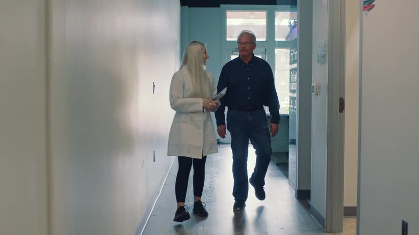 A doctor and patient walk through a doctors office