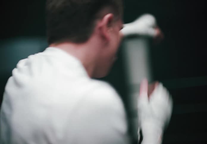 Male boxer shadow boxes while training in the gym
