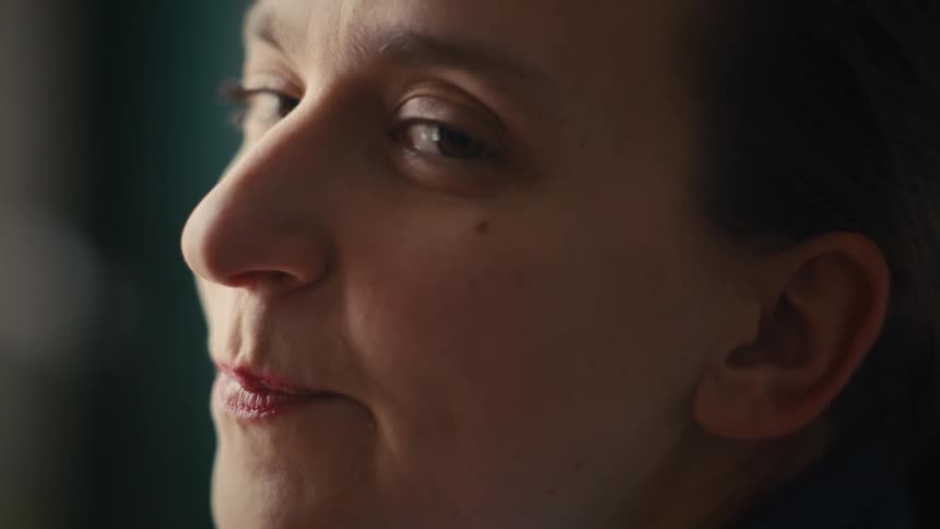 A woman is looking to her side while smiling