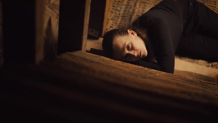 Woman stares while lying on her side on the floor